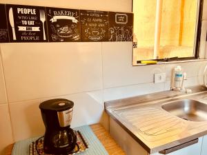 a kitchen with a coffee maker sitting next to a sink at Casa Amarela in Praia Grande +15 photos