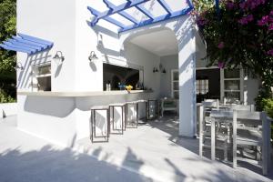 a patio with chairs and a bar in a building at Hippocampus Hotel in Kamari