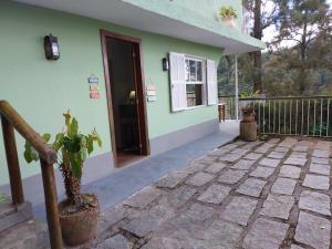 a house with a patio and a door at Pousada Alto Itaipava in Itaipava