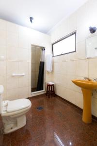 a bathroom with a toilet and a sink at Daher Center Hotel in São Paulo