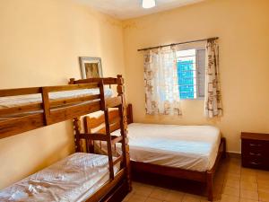 a bedroom with two bunk beds and a window at Casa Amarela in Praia Grande