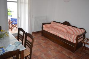un sofá en una sala de estar con mesa y sillas en Maryianni Apartments, en Avlemonas