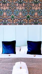 a bed with blue pillows and a table on it at La Flor del Camino Posada in Tanti