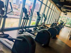 a gym with rows of cardio machines in a building at Aveline Suites Executive City View ACQUA Private Residences near Rockwell Makati in Manila
