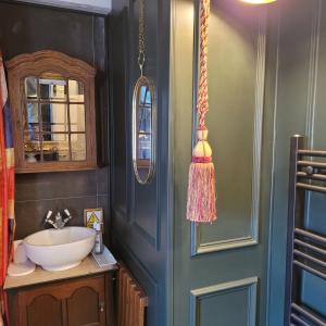 a bathroom with a sink and a mirror at 8 Opera Suites, Llangollen in Llangollen