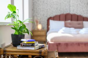 a bedroom with a bed and a table with books at Neighbourhood Bedrooms in Cardiff