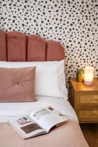 a book laying on a bed with a wall at Neighbourhood Bedrooms in Cardiff