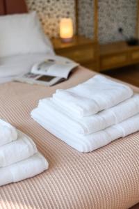 three towels are stacked on top of a bed at Neighbourhood Bedrooms in Cardiff