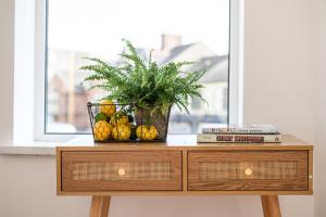a wooden dresser with a vase of fruit on it at Neighbourhood Bedrooms in Cardiff