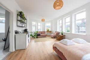 a white bedroom with a bed and a living room at Neighbourhood Bedrooms in Cardiff