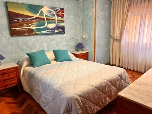 1 dormitorio con 1 cama y una pintura en la pared en La casita de la abuela, en Villarcayo