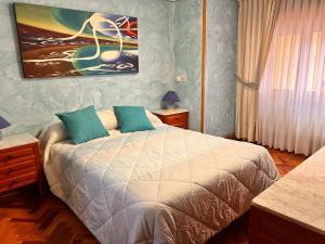 a bedroom with a bed and a painting on the wall at La casita de la abuela in Villarcayo