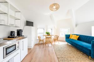 a living room with a blue couch and a table at Neighbourhood Bedrooms in Cardiff