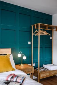 a bedroom with a green wall with a bunk bed at Neighbourhood Bedrooms in Cardiff