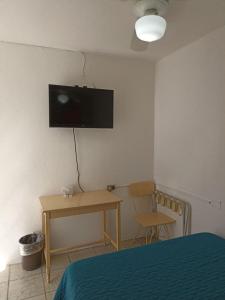 1 dormitorio con cama, escritorio y TV en la pared en Hotel Metropolitan II, en Irapuato