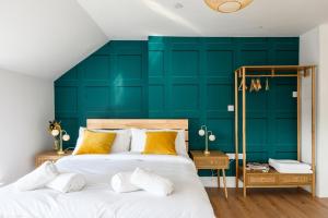 two beds in a bedroom with a green wall at Neighbourhood Bedrooms in Cardiff