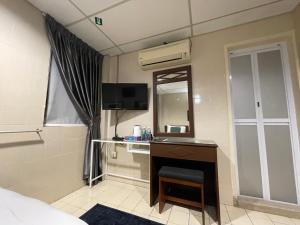 a hotel room with a desk and a mirror at Barrack Street Hotel in Taiping