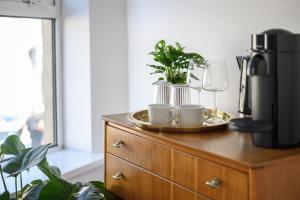 a wooden dresser with two cups and plants on it at Neighbourhood Bedrooms in Cardiff