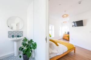 a bedroom with a bed and a sink and a mirror at Neighbourhood Bedrooms in Cardiff