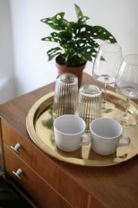 a tray with wine glasses and a plate on a dresser at Neighbourhood Bedrooms in Cardiff