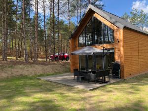 a small cabin with a table and chairs on a patio at Grzybowska Osada in Grzybowo