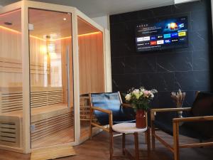 聖康坦的住宿－Elo Spa，一个带两把椅子的沙龙和墙上的电视