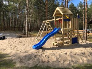 a playground with a slide in the sand at Grzybowska Osada in Grzybowo