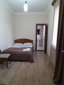 um quarto com uma cama e um espelho em Yeganyans Guest House and Wine Yard em Ashtarak