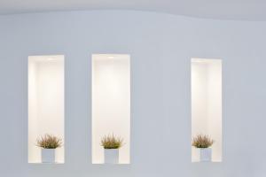 three windows with potted plants in them at Hippocampus Hotel in Kamari