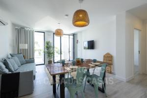 - une salle à manger avec une table et un canapé dans l'établissement Ribamar Bluevillas T1 by ACasaDasCasas - Apartment 3, à Ericeira