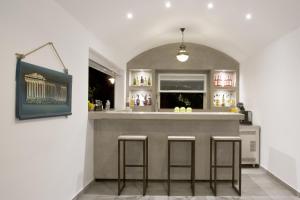 a bar with three bar stools in a room at Hippocampus Hotel in Kamari