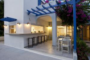 a patio with a bar in a villa with flowers at Hippocampus Hotel in Kamari
