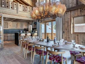 a dining room with a table and chairs and a chandelier at Chalet Les Belleville, 8 pièces, 15 personnes - FR-1-570-25 in Saint-Martin-de-Belleville