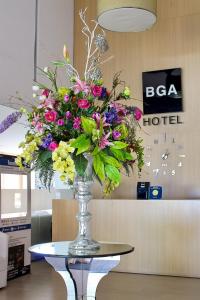 un jarrón lleno de flores sobre una mesa en BGA Hotel, en Bucaramanga