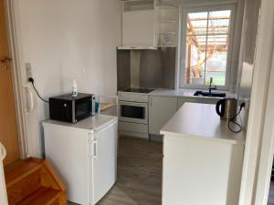 uma cozinha com armários brancos e um micro-ondas preto em Idyllic country house em Vadum