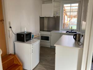 a kitchen with white cabinets and a black microwave at Idyllic country house in Vadum