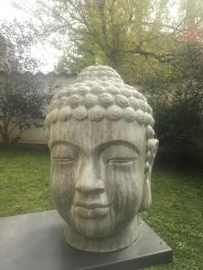 une statue de tête dans un jardin dans l'établissement Appartement très calme avec jardin plein sud, à Lyon