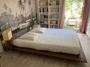 - un grand lit dans une chambre avec une étagère dans l'établissement Appartement très calme avec jardin plein sud, à Lyon