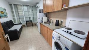 een keuken met een wasmachine en droger in de kamer bij city holiday in Rishon LeẔiyyon