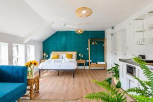 a bedroom with a bed and a blue wall at Neighbourhood Bedrooms in Cardiff
