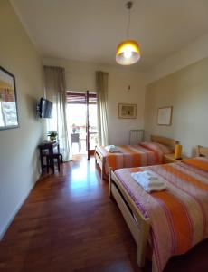 Habitación con 2 camas, mesa y TV. en Le Stanze di Nonna Lina en Pagani