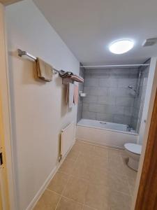 a bathroom with a toilet and a bath tub at Laura's Place in Isleworth