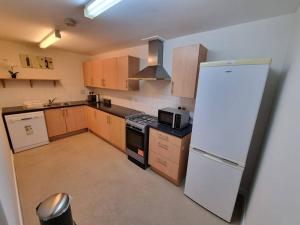 a kitchen with a white refrigerator and a stove at Laura's Place in Isleworth