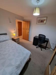 a bedroom with a bed and a desk and a chair at Laura's Place in Isleworth