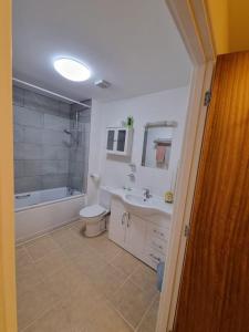 a bathroom with a sink and a toilet and a bath tub at Laura's Place in Isleworth