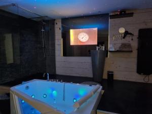eine Badewanne in einem Zimmer mit einer Uhr an der Wand in der Unterkunft Love Loft in Bordeaux