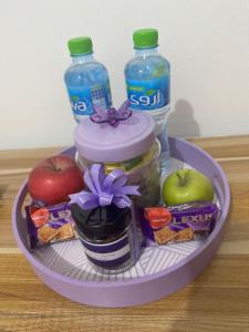 a tray of food with apples and a bottle of water at The Purple Place in Abu Dhabi