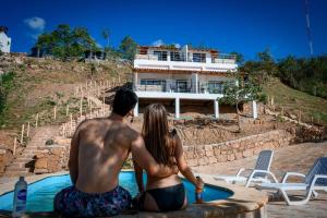 a man and a woman sitting next to a swimming pool at GLAMPING SAN GIl EXPLORE in San Gil