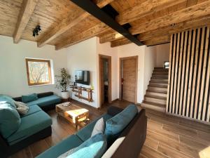 un soggiorno con divani blu e soffitto in legno di Refugio del nogal - Cercedilla a Cercedilla