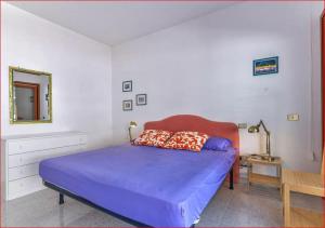 Un dormitorio con una cama azul y un espejo. en Appartamenti La Colombaia, en Porto Azzurro 23 fotos más